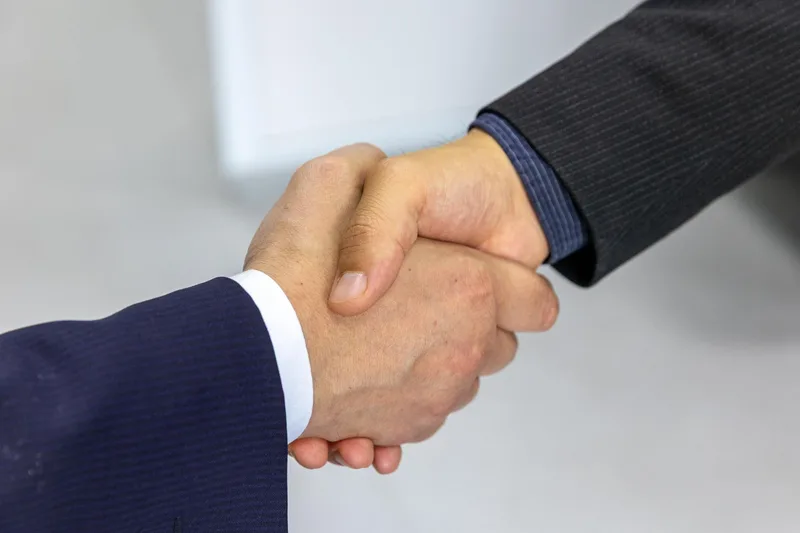 Close-up of two businessmen shaking hands, symbolizing agreement and partnership