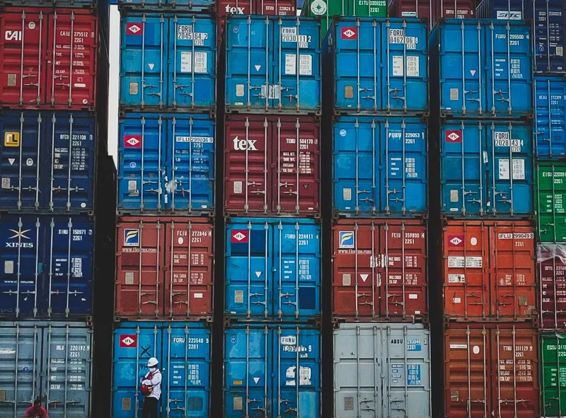 Stacked cargo shipping containers at a busy port