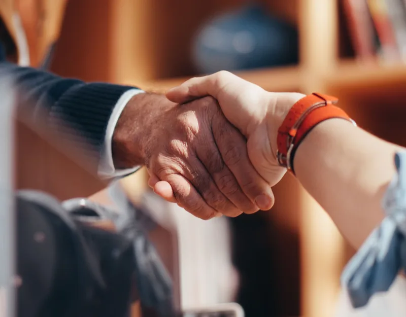 Close-up of two people shaking hands in a business handshake, symbolizing partnership